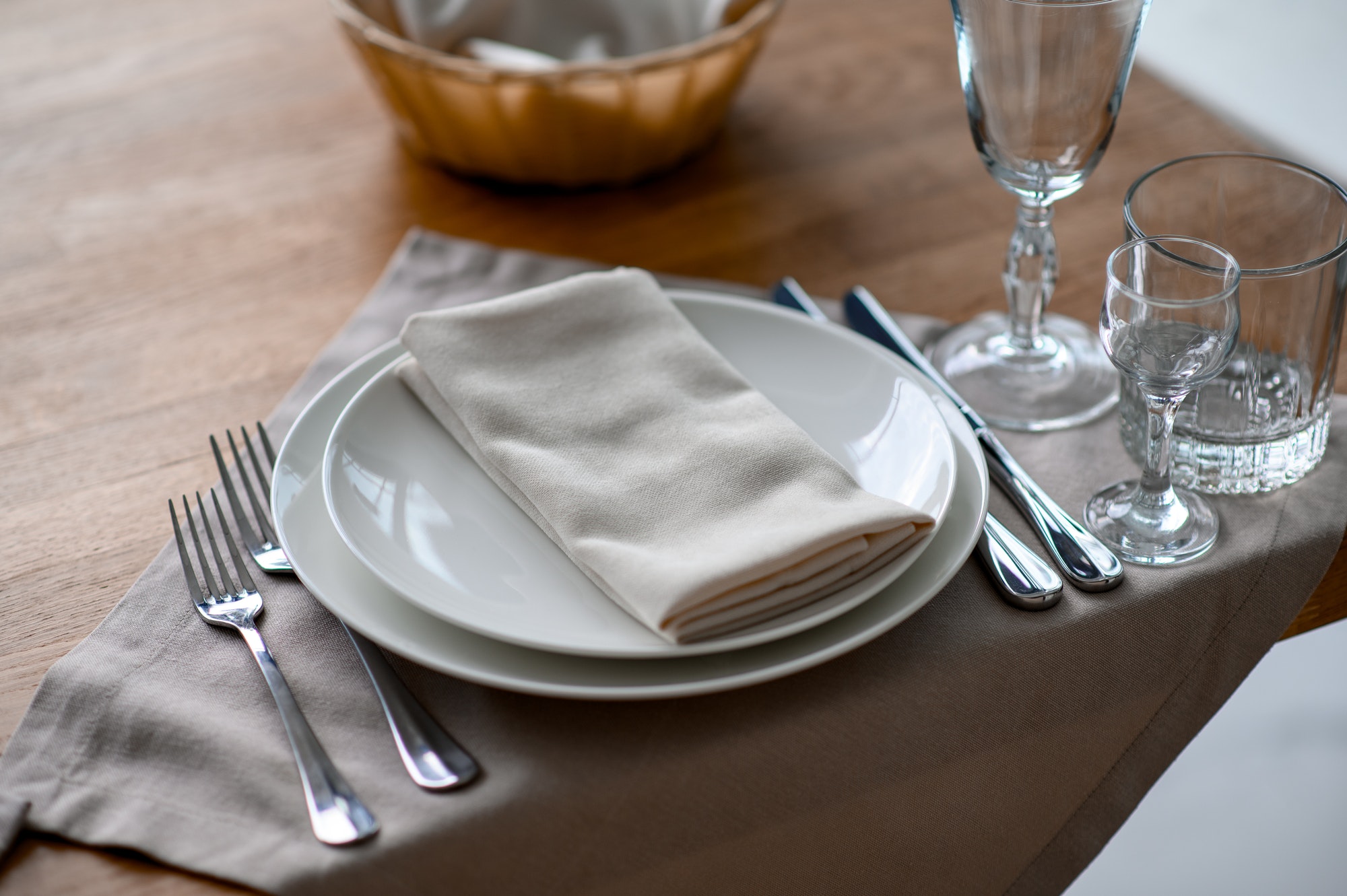 Festive romantic table setting with silverware, gray napkin and white crockery